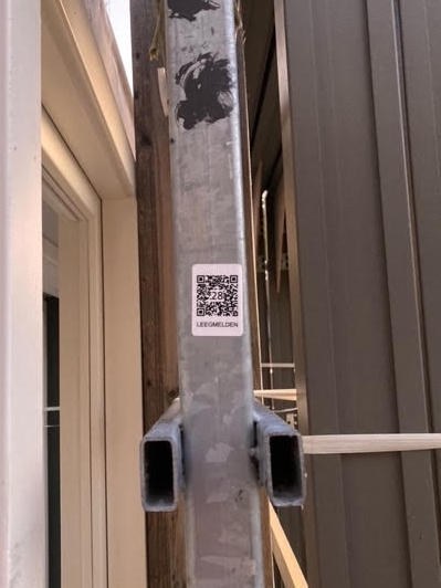 QR-code met tekst 'leegmelden' op een stalen frame voor de kozijnen.
