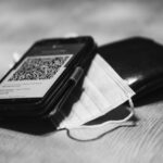 Wallet and phone with a QR code on top.